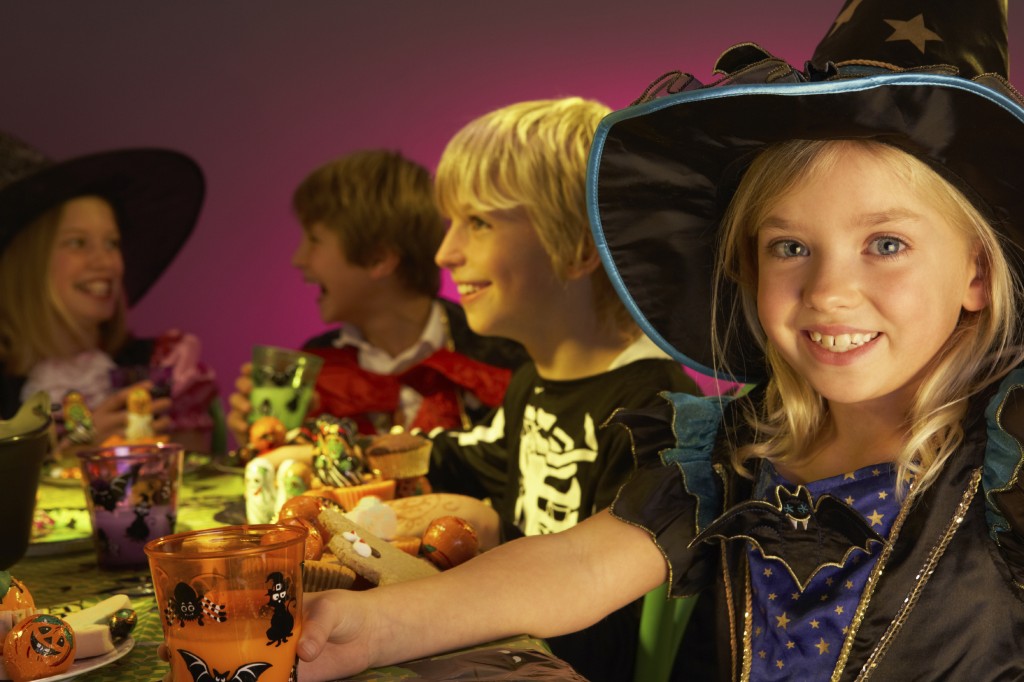 Halloween party with children having fun in fancy costumes
