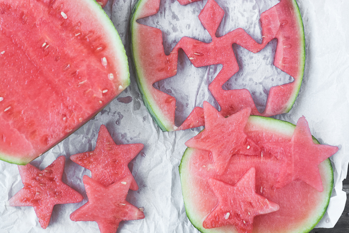Star Spangled Fruit Infused Water Cutting watermelon stars for a healthy red white and blue themed infused water for the 4th