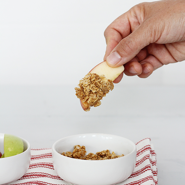 an apple slices with peanut butter and granola